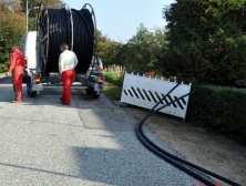 Glasfaserverlegung: Kabeltrommel, Kabel auf Straße, Fahrzeug, Arbeiter